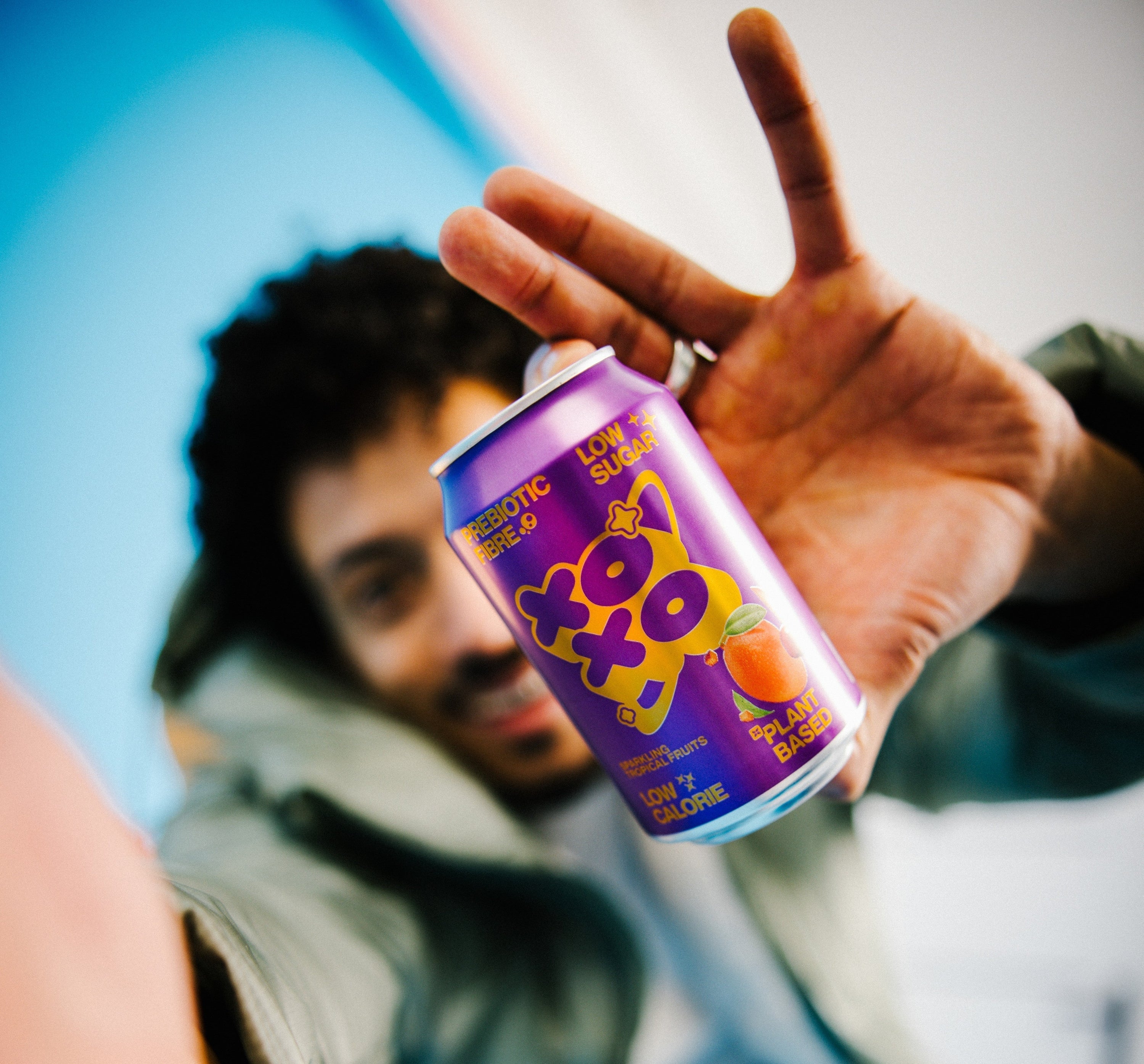 Person holding a can of XO Soda, promoting XO Soda health benefits with low sugar and great taste.