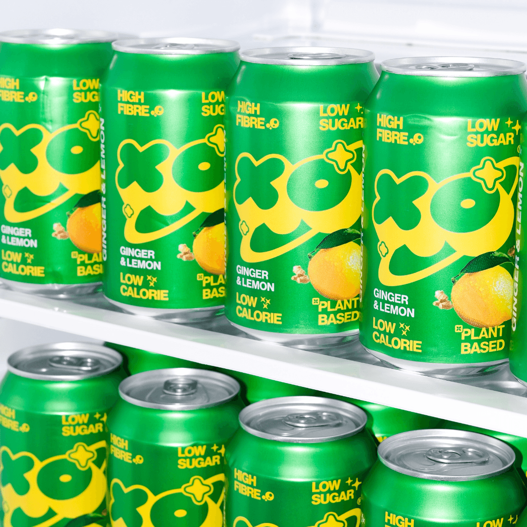 XO Ginger Lemon Soda 12 pack cans in green packaging, featuring low sugar, high fibre, and plant-based ingredients.